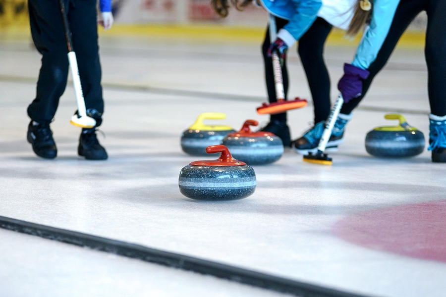 Curlingsteine rutschen über das Eis