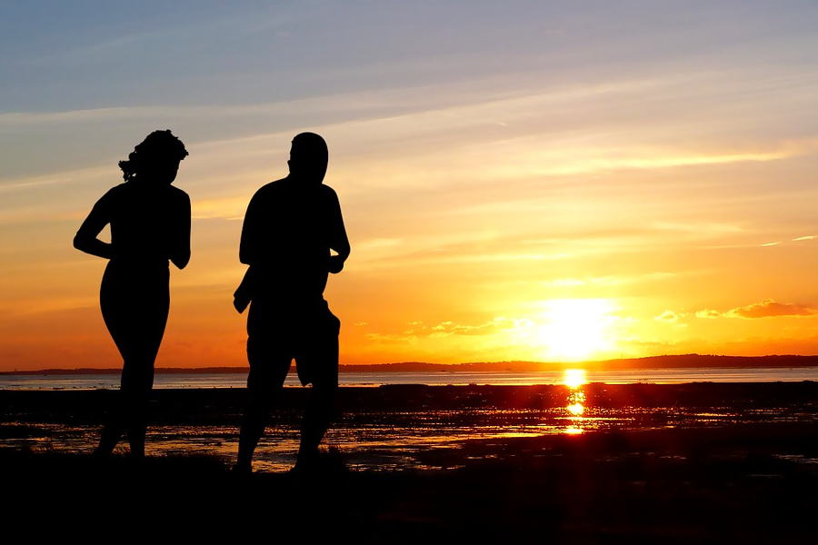 Mann und Frau joggen in den Sonnenuntergang