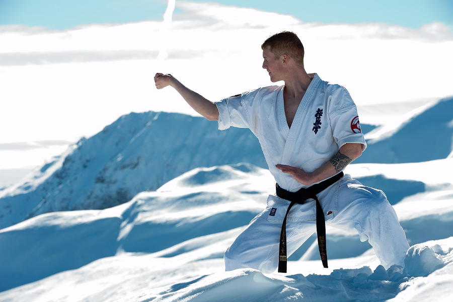 Karateka im Schnee in den Bergen
